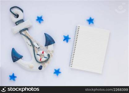 small wooden anchor with blank notebook
