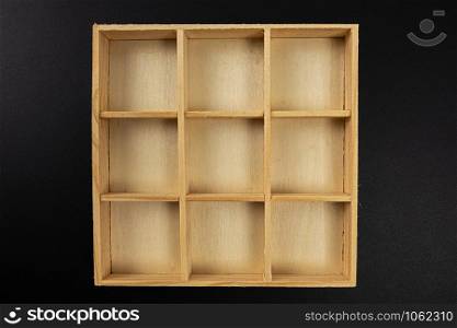 small wooden box with nine divisions isolated on black background