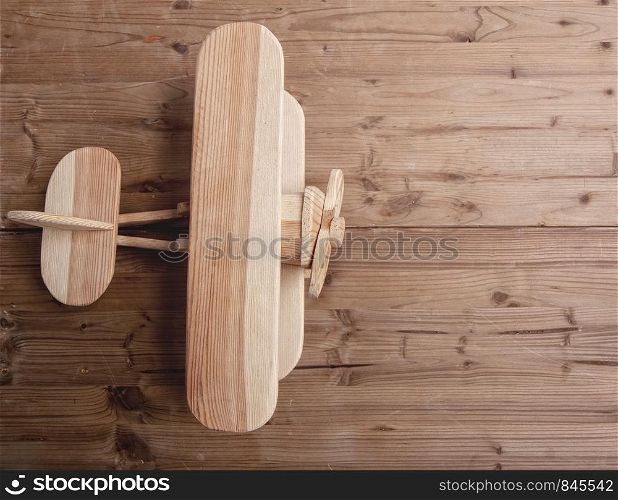 small wooden childrens plane biplane on a wooden background. old wooden Airplane