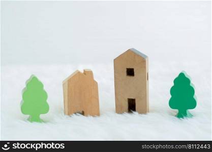 Small wooden model house and building with green trees in residential areas. Coexistence with nature concept. White background