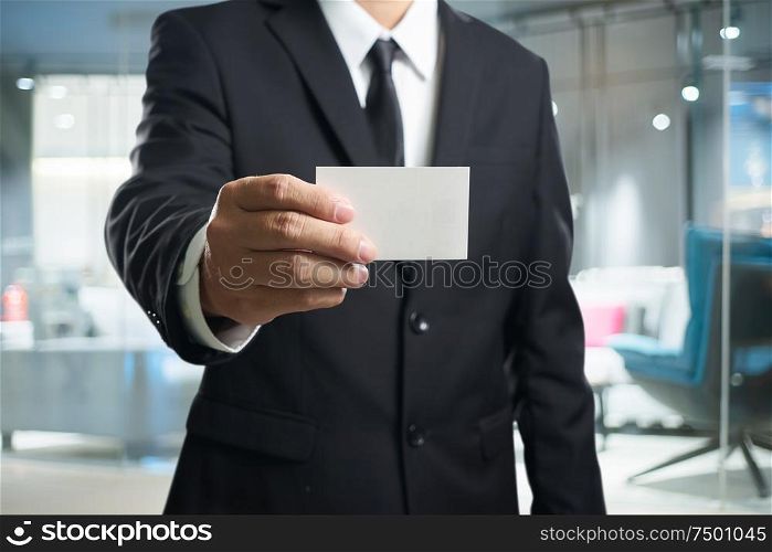 Smart businessman in black suit with show the name card pose .