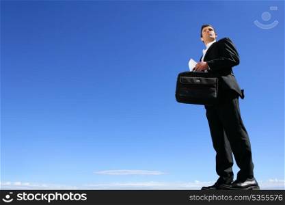 Smart businessman in front of blue sky