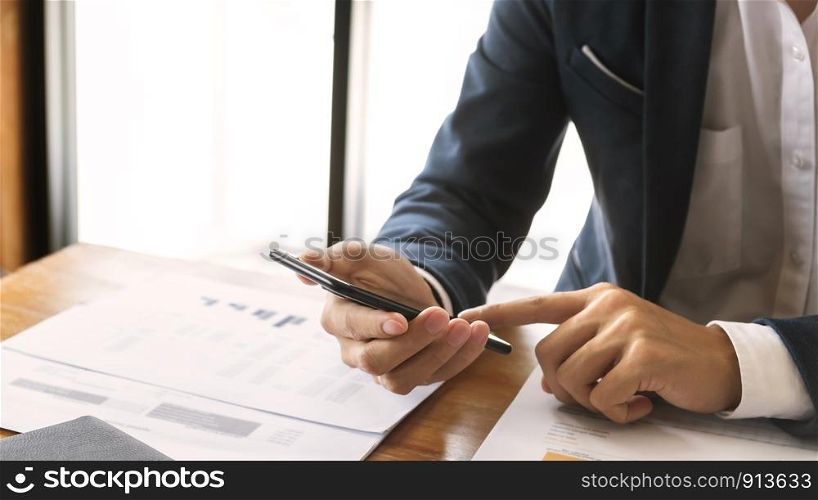 Smart businessman using mobile phone in an office.