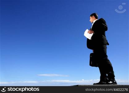 Smart businessman with sky in background