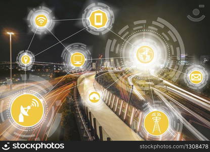 Smart city wireless communication network with graphic showing concept of internet of things (IOT) and information communication technology (ICT) against modern city buildings in the background.