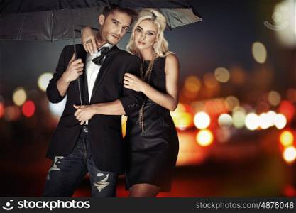 Smart couple walking with the black umbrella