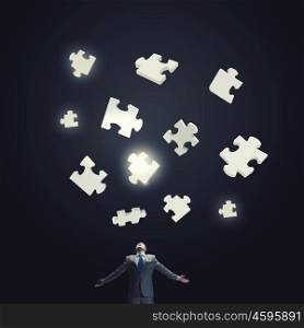 Smart enough to solve problem. Smart mature businessman and puzzle elements above