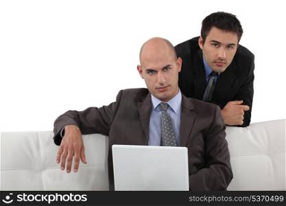 Smart executives sitting with a laptop