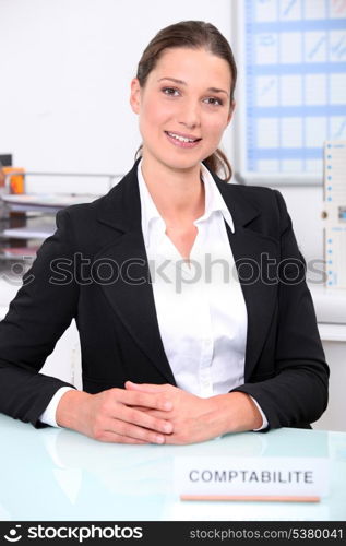 Smart female accountant sitting at her desk