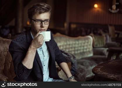 Smart guy drinking an aromatic coffee