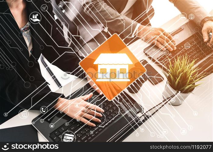 Smart Home with Computer Control Concept. Businessman and businesswoman working on laptop computers at office desk with logo of smart home.