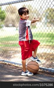 Smart kid posing with basketball as he holds it under his leg