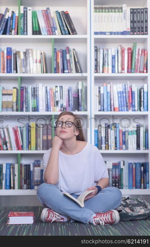 smart looking famale student girl in collage school library reading book