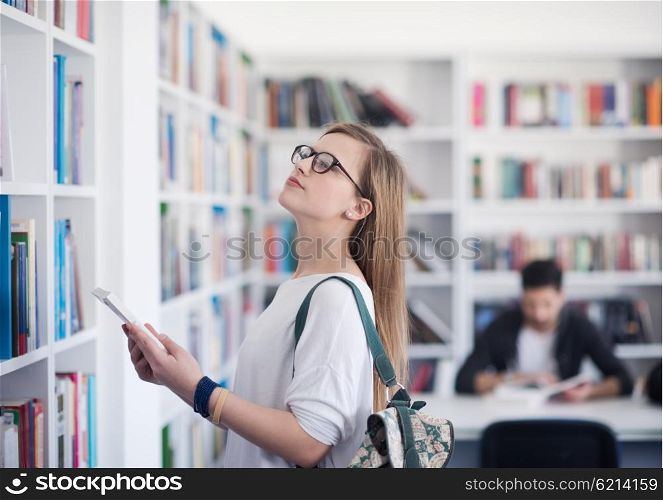 smart looking famale student girl in collage school library selecting book to read