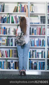 smart looking famale student girl in collage school library selecting book to read