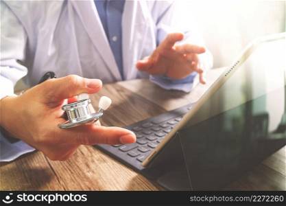smart medical doctor hand working with smart phone,digital tablet computer,stethoscope eyeglass,on wood desk,filter effect