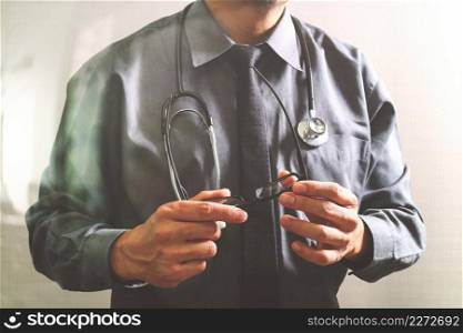 smart medical doctor holding eyeglass,stethoscope ,front view,filter effect