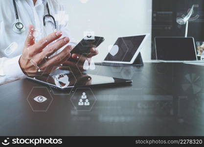 smart medical doctor working with smart phone and digital tablet and laptop computer on dark wooden desk in modern office with virtual icon diagram