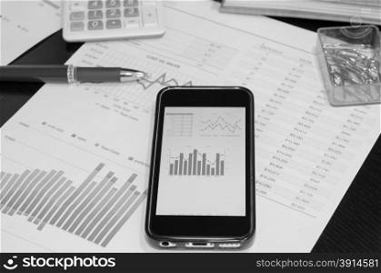 smart phone and chart on the table.picture black and white