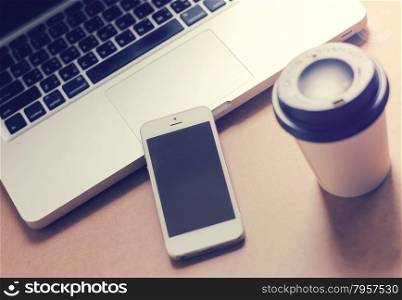 Smart phone and notebook computer with coffee cup, retro filter style toned