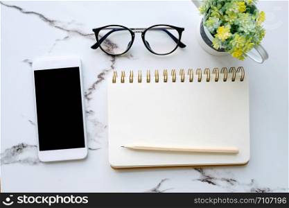 Smart phone with blank screen and blank notebook paper background, mock up, flat lay