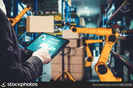 Smart robot arm systems for innovative warehouse and factory digital technology . Automation manufacturing robot controlled by industry engineering using IOT software connected to internet network .. Smart robot arm systems for innovative warehouse and factory digital technology