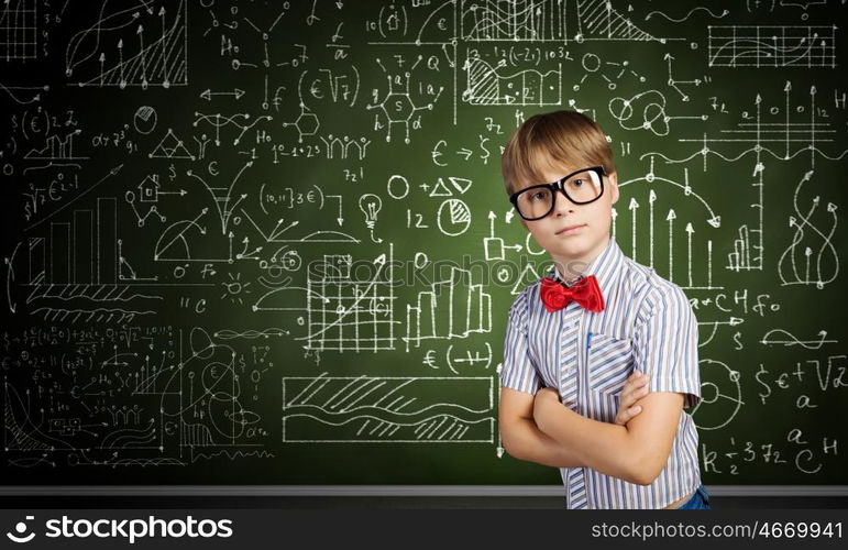 Smart schoolboy. Genius boy in red glasses near blackboard with formulas