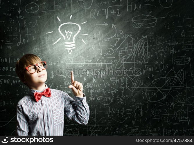 Smart schoolboy. Genius boy in red glasses near blackboard with formulas