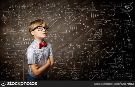Smart schoolboy. Genius boy in red glasses near blackboard with formulas