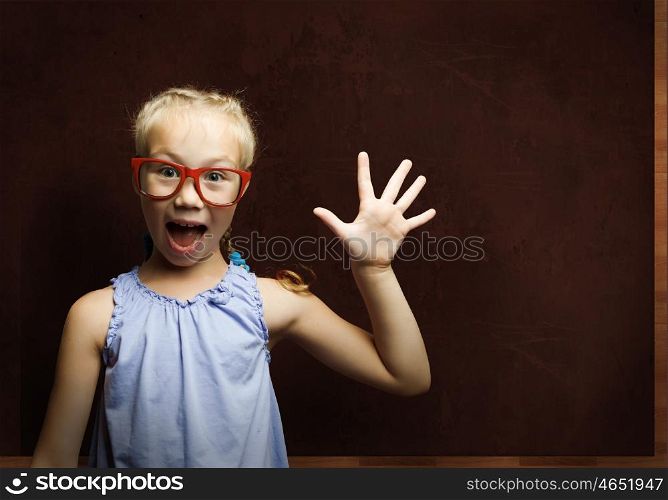 Smart schoolgirl. Genius girl in red glasses near blackboard with formulas