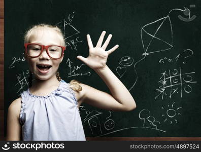 Smart schoolgirl. Genius girl in red glasses near blackboard with formulas