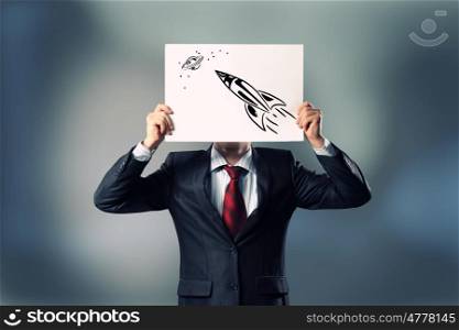 Smart thinking. Businessman hiding her face behind paper sheet with sketches