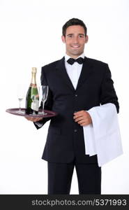 Smart waiter holding tray of champagne glasses