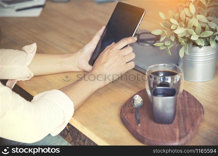 Smart woman using tablet after work at the coffee shop.