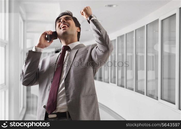 Smart young business man celebrating his success at office