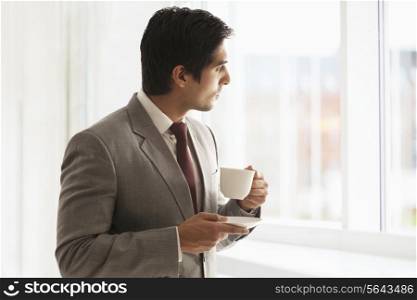 Smart young businessman taking coffee break at office