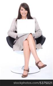 Smart young woman sitting in a swivel chair with a laptop computer