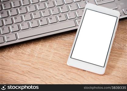 Smartphone laying on laptop keyboard with copy space on screen