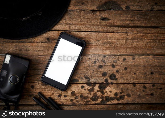 Smartphone white screen on wooden table.Top view  . Smartphone white screen on wooden table.  