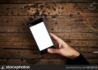 Smartphone white screen on wooden table.Top view  . Smartphone white screen on wooden table.  