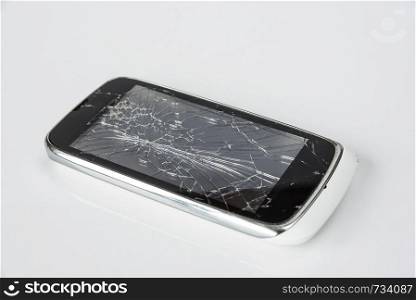 Smartphone with a broken screen closeup on white background. Phone repair concept