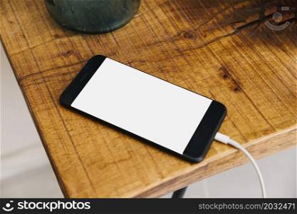 smartphone with blank white screen wooden desk