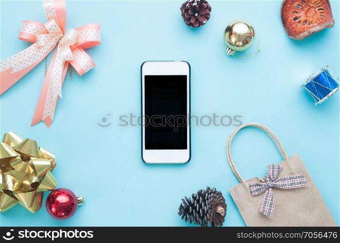 Smartphone with Christmas decorations. Christmas mock up template on pastel color. View from above