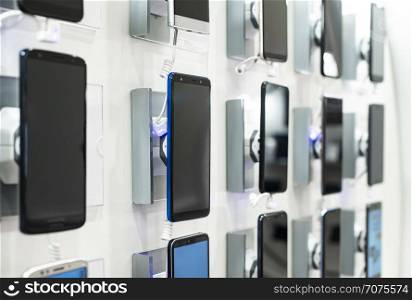 Smartphones on shelf in the store. Concept for communications and technology. Buying mobile phone in technology shop.