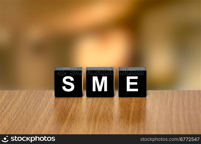SME or Small and medium-sized enterprises on black block with blurred background
