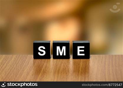 SME or Small and medium-sized enterprises on black block with blurred background
