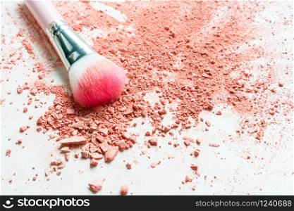 Smear of crushed orange blush on as sample of cosmetics product and brush, copy space, top view