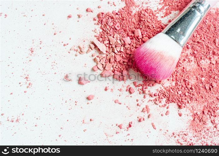 Smear of crushed pink blush on as sample of cosmetics product and brush, copy space, top view