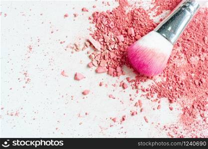 Smear of crushed pink blush on as sample of cosmetics product and brush, copy space, top view