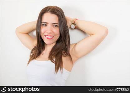 smiiling woman leaning against the white wall